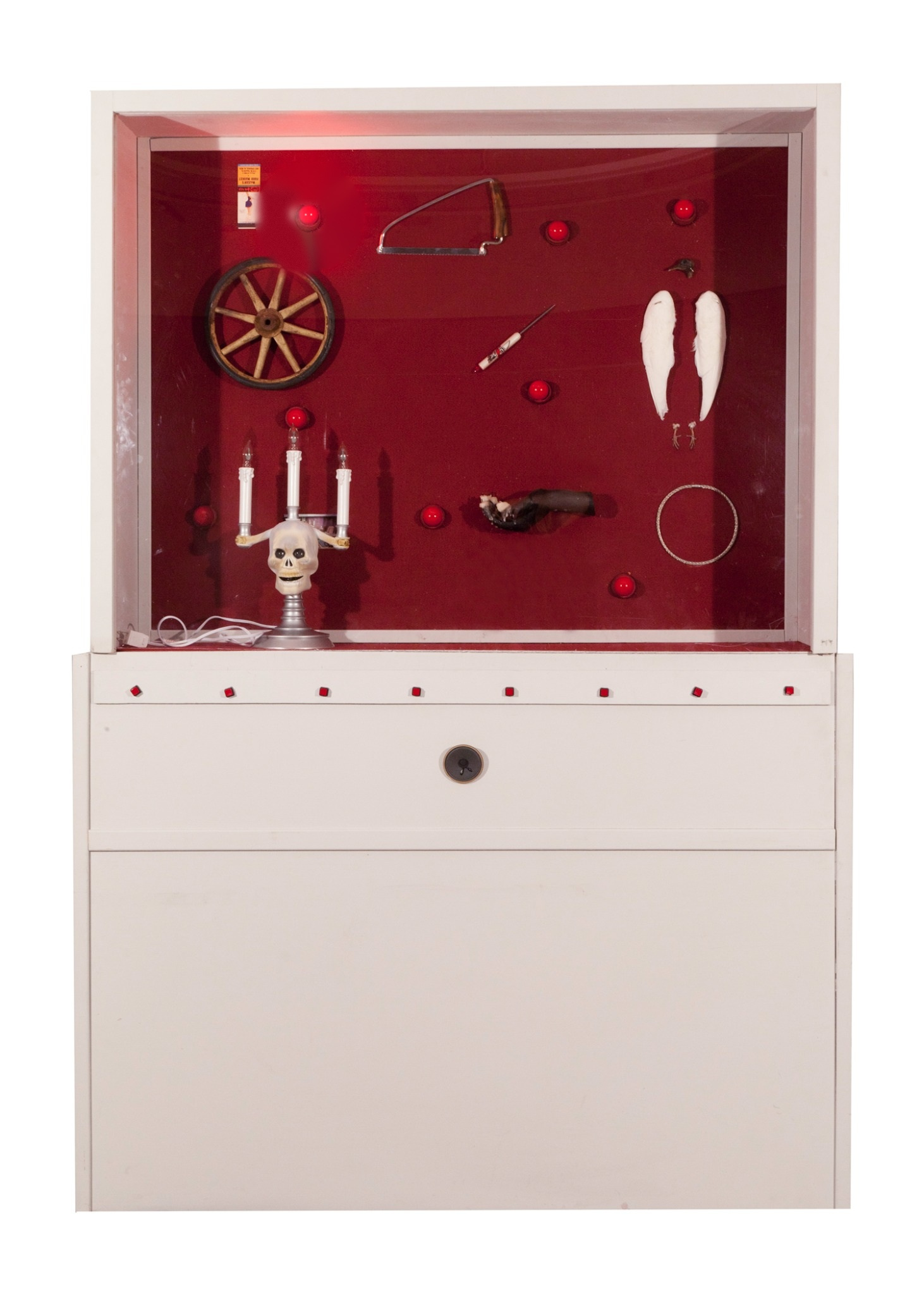 White museum cabinet containing eight objects in a burgundy felt-lined case, with eight red buttons below the glass.